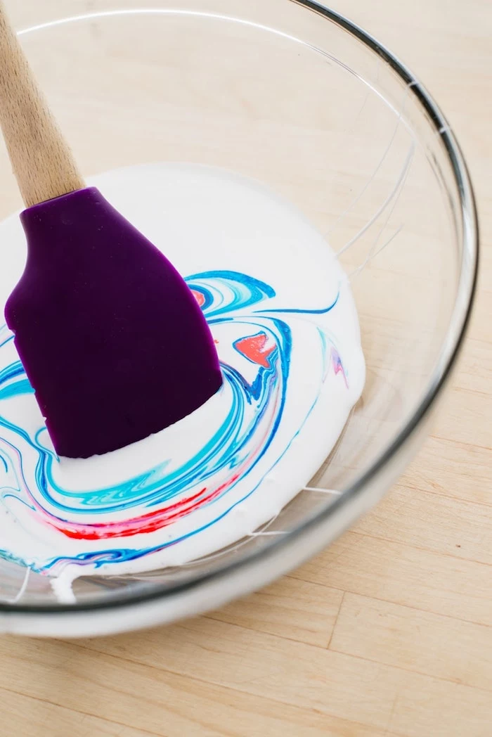 mixing red and blue paint, in a clear glass bowl, with white compound, fluffy slime recipe, using a purple plastic spatula