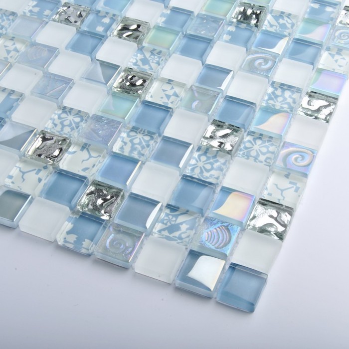 shades of blue and silver, on small square tiles, sheer and opaque, glass mosaic tile backsplash example, placed on a white surface 