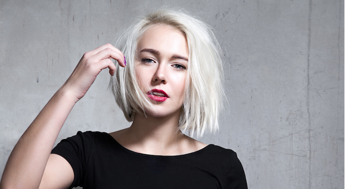 short haircuts for fine hair, platinum blonde messy bob, with deep side part, worn by woman in black t-shirt, with red lipstick