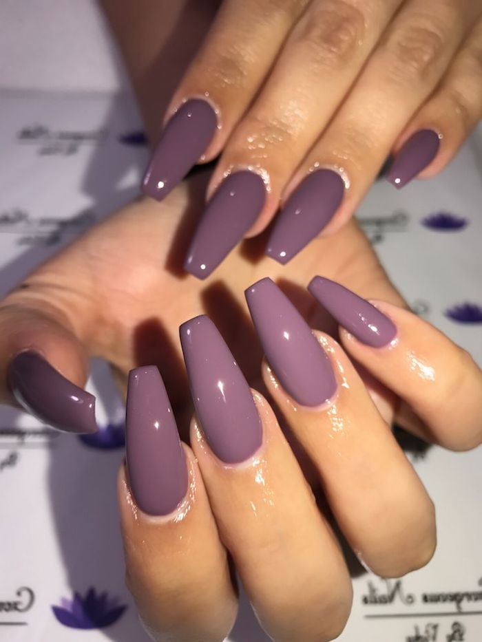 milky purple nail polish, glossy and smooth, on long coffin acrylic nails, attached to two hands, resting on a white, patterned background