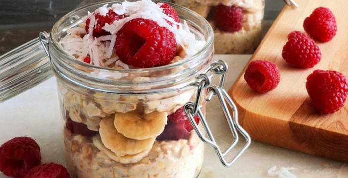 shaved coconut pieces, raspberries and banana slices, in a snap lid jar, filled with creamy oats, best breakfast for weight loss, cutting board with raspberries