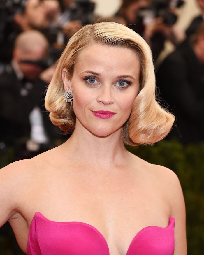 retro blonde curls, styled on a long bob, with deep side part, short hairstyles for fine hair, worn by reese witherspoon, in a hot pink strapless top, with matching lipstick