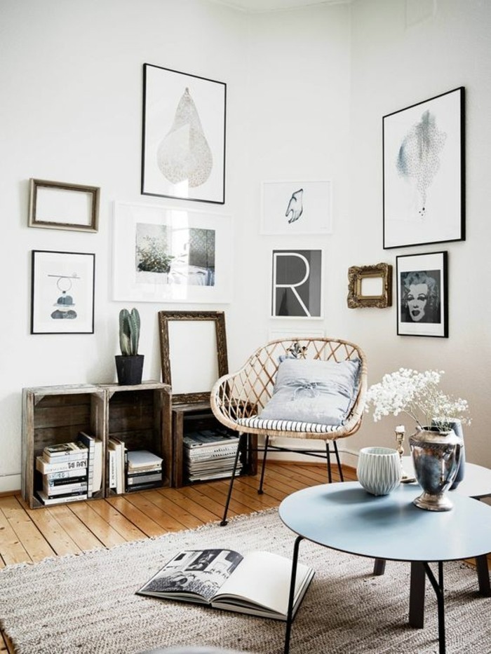 old wooden crates, transformed into bookshelves, inside a nordic style room, with wooden floor, beige rug and a wicker chair