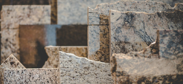 broken marble or granite tiles, with sharp jagged edges, in beige with grey and brown patterns, seen in close up