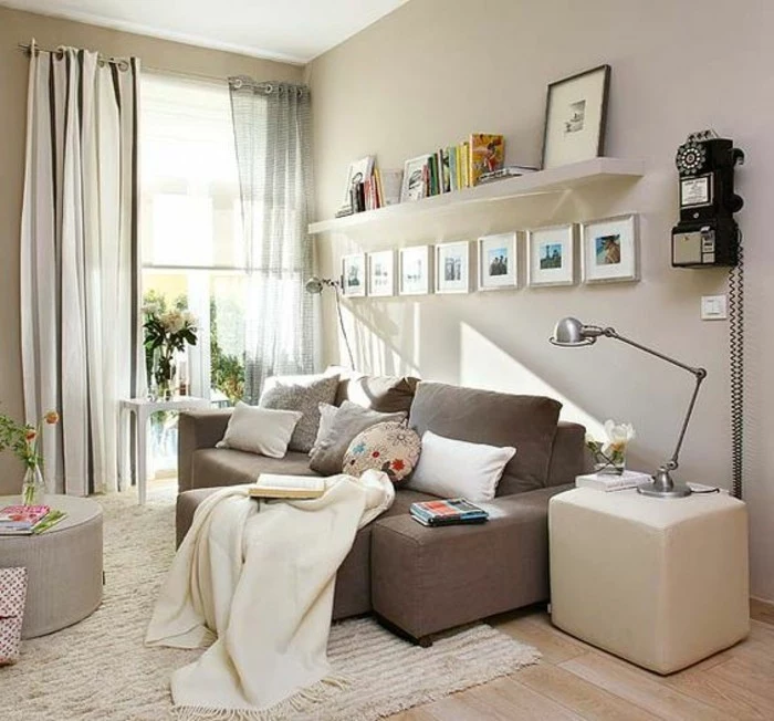 seven images in silver frames, on a pale beige wall, inside a bright living room, with laminate floor, and light beige rug, couches for small living rooms