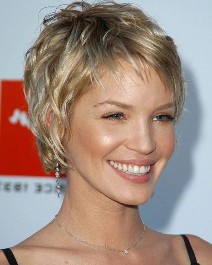 big smile on a blue-eyed woman, with short wavy, textured pixie cut, in dark and light blonde, short haircuts for thin hair, black strappy top