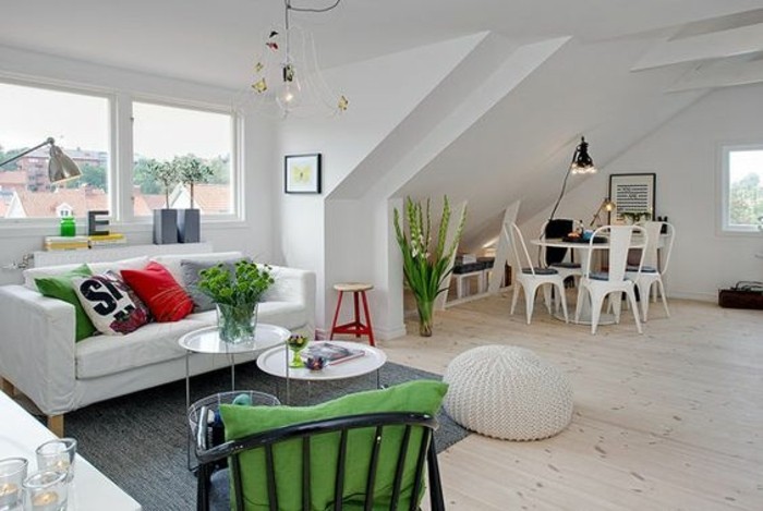 green cushions and potted plants, inside a spacious white studio, with pale beige laminate floor, white sofa and two coffee tables, and a dining area, home decor inspiration