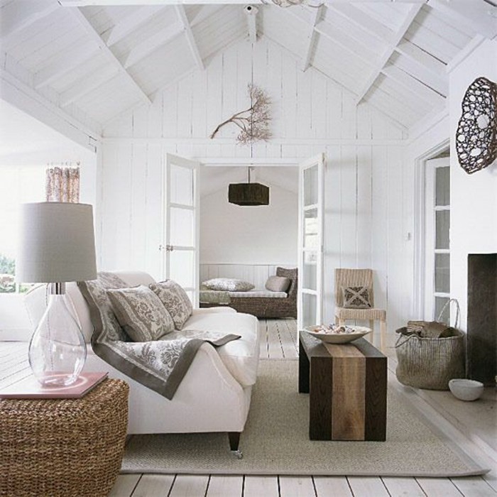 vaulted ceiling in white, inside a living room, with white wooden paneling, room design, light beige floor, with a beige rug, white sofa and wooden furniture
