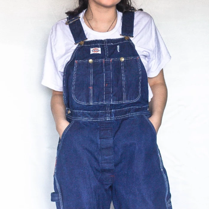 baggy retro denim overalls, in indigo blue, worn over a plain white t-shirt, by a dark-haired woman, 90s themed outfits