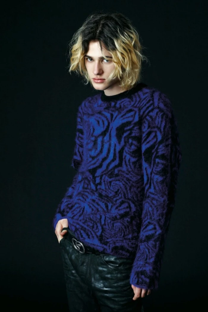 oversized fluffy sweater, electric blue with black animal print, worn by a young man, 90s outfit ideas, with black leather trousers, and shoulder length curly hair