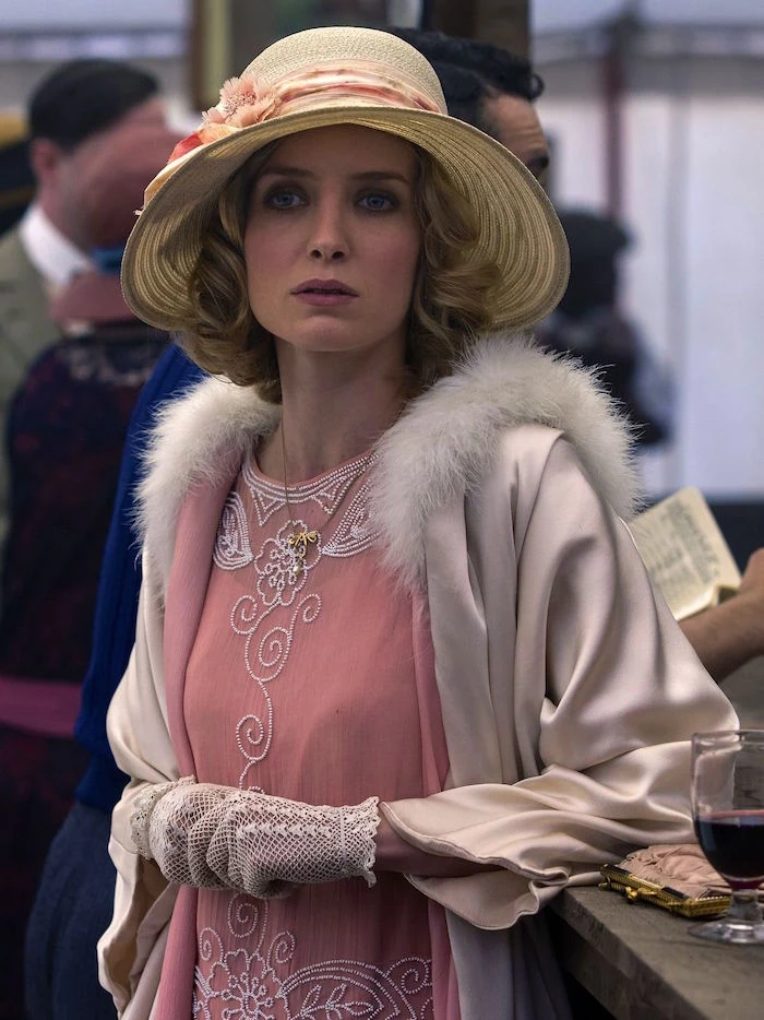 peach pink flapper dress, embroidered with white beads, worn with a cream satin coat, featuring a white lace trim, and crochet lace gloves, great gatsby outfits, annabelle wallis in peaky blinders