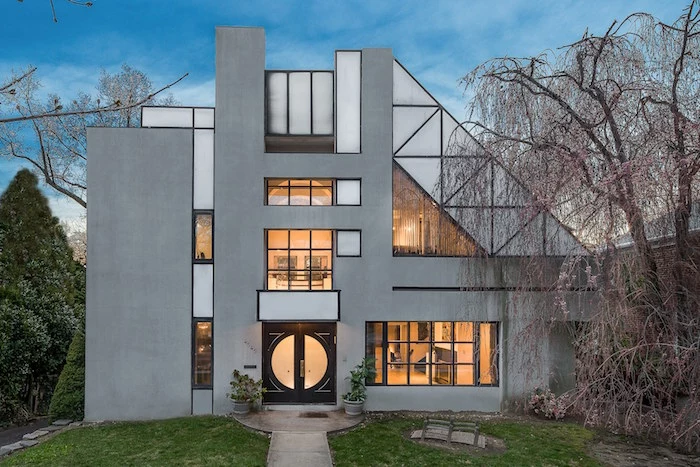 grey and off-white house, with lots of windows in different shapes and sizes, postmodern architecture, asymmetrical structure with geometrical motifs
