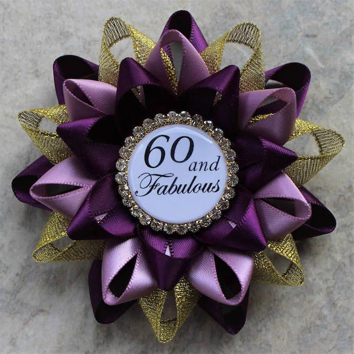 brooch made from purple, pink and gold mesh ribbons, with a badge reading 60 and fabulous