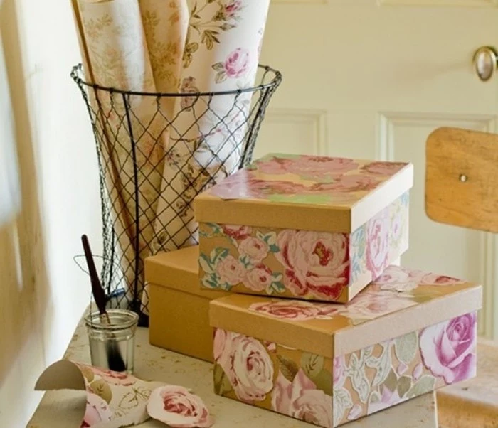 last minute birthday gifts, beige cardboard boxes, decorated with pink and green, floral paper decoupage, rolls of patterned paper, a jar with glue, and a brush nearby