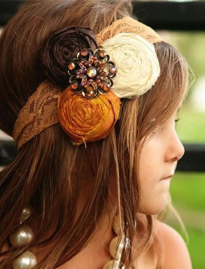 beige lace headband, decorated with flower motifs in orange, cream and dark brown, on the smooth, long brunette hair, of a young child, simple hairstyles, oversized pearl-like necklace