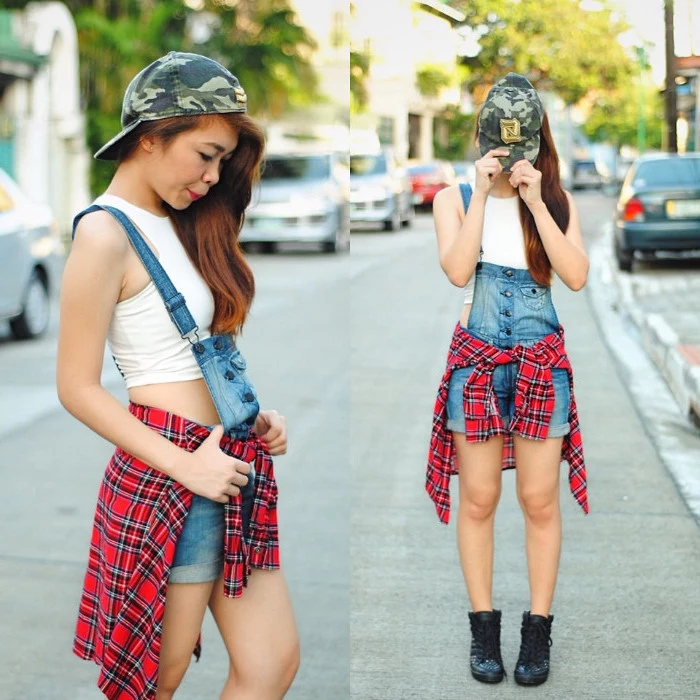 baseball cap with green camouflage print, worn by auburn-haired young woman,90s inspired outfits, white crop top, short denim overalls, and a flannel shirt 