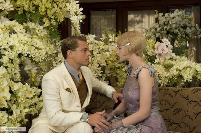 still from baz luhrmann's the great gatsby, featuring leonardo di caprio and carey mulligan, in great gatsby costumes, surrounded by white flowers