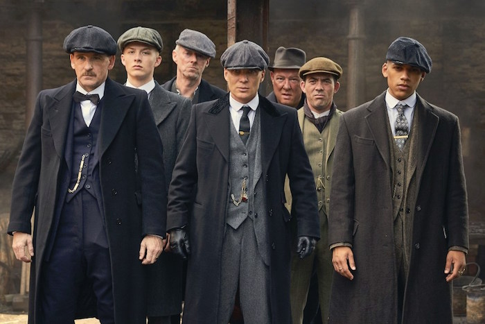 characters from bbc's tv series peaky blinders, dressed in 1920s attire, dark three-piece suits, and wollen caps, great gatsby outfits, woolen winter coats