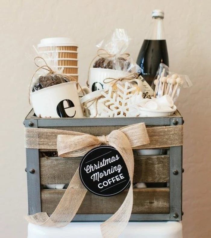 crate made from metal and wood, containing paper cups, packets with coffee beans, cute gift ideas, marshmallows and a bottled beverage