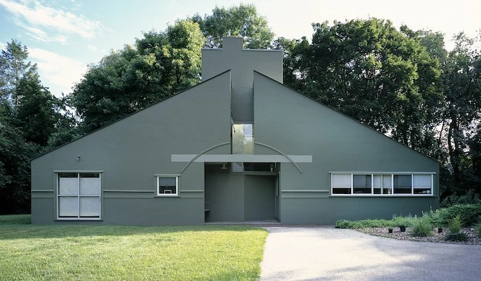 vanna venturi house, with divided gabled roof, and a large rectangular chimney, post modernity, several small and one large window
