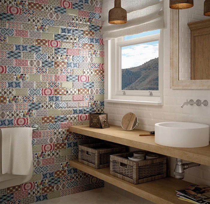 mismatched patterns and different colors, on patchwork-effect subway tiles, covering one of the walls of a nordic-style bathroom