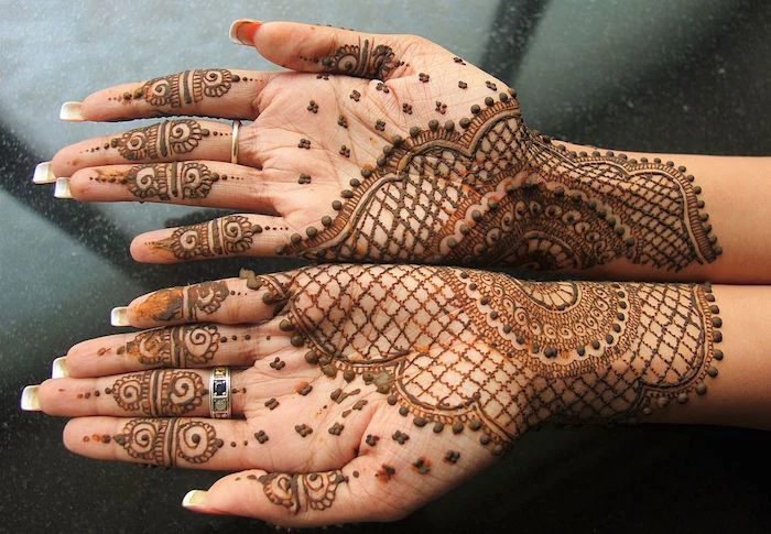 one large image, formed by the temporary henna tattoos of two palms, pressed together, traditional bridal mehndi