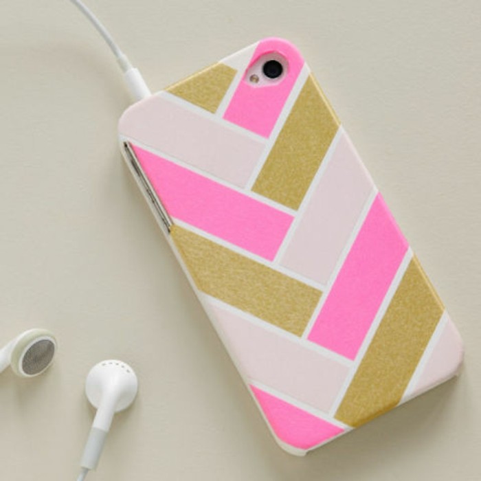 cute gift ideas, mobile phone case in white, decorated with hot pink, shimmering gold and pale pink strips, white earplugs attached to it