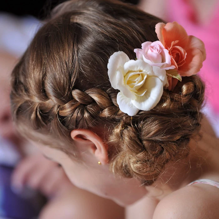 braided brunette hair, decorated with three roses in different colors, cream and pale pink, and pastel orange, on the head of a child, hairstyles for little girls, seen in close up