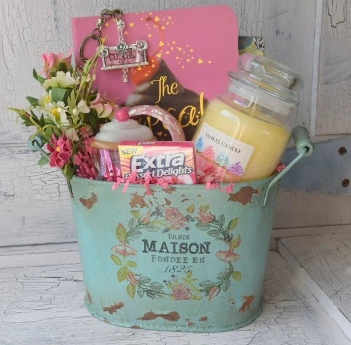rusty teal bucket, decorated with floral decoupage, and containing candy, flowers and a candle, cute gift ideas, various other items