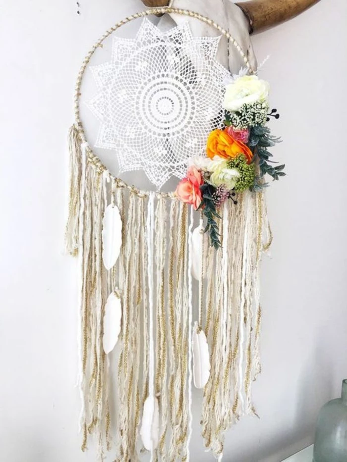 boho-style dreamcatcher, white crochet lace doily, and cream tassels, decorated with white feather ornaments, big dream catchers, pale yellow and orange, green and pink flowers