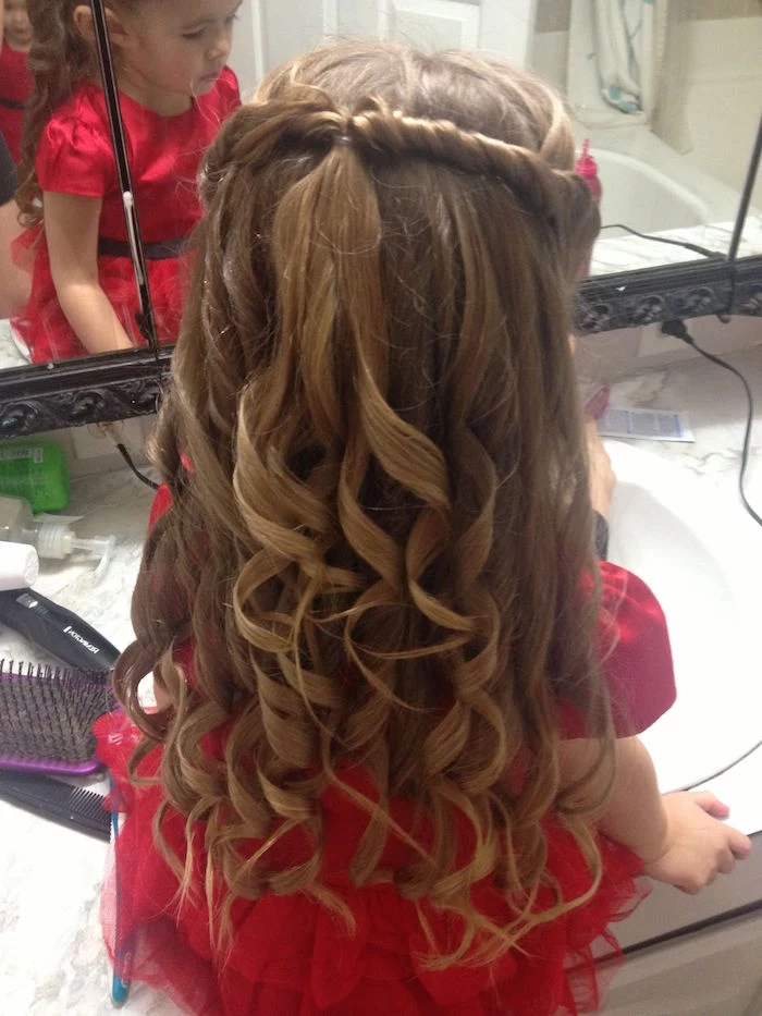 ringlet-like curls, on a long brunette hair, with joined side twists at the top, worn by a small girl, in a fancy red dress