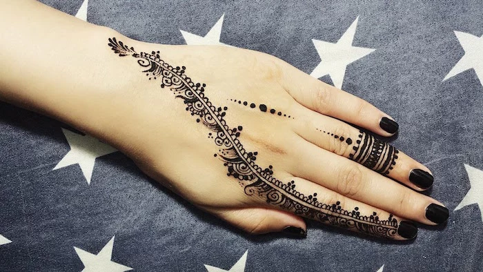 black ring-like motifs, dots and a long, curved detail, running from the wrist, to the index finger, finger henna tattoo ideas