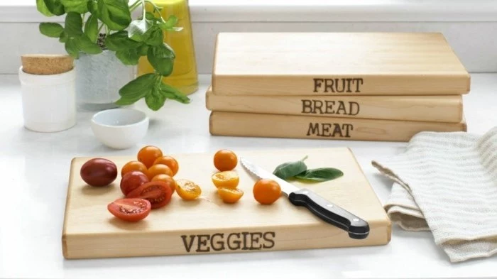 wooden cutting boards, decorated with customized inscriptions, last minute birthday gifts, cherry tomatoes and basil leaves, near a small knife, on one of the boards