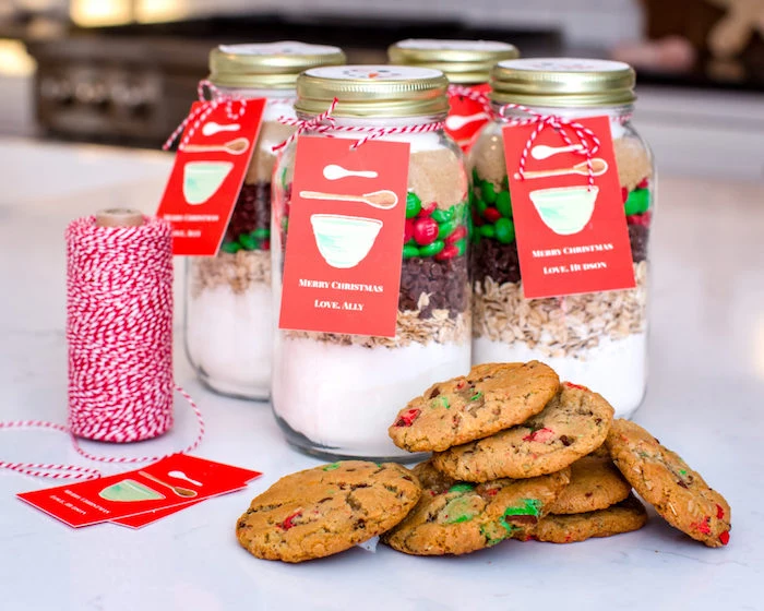 deconstructed cookies in mason jars, homemade christmas gifts, baked cookies at the front, red and white ribbon decoration