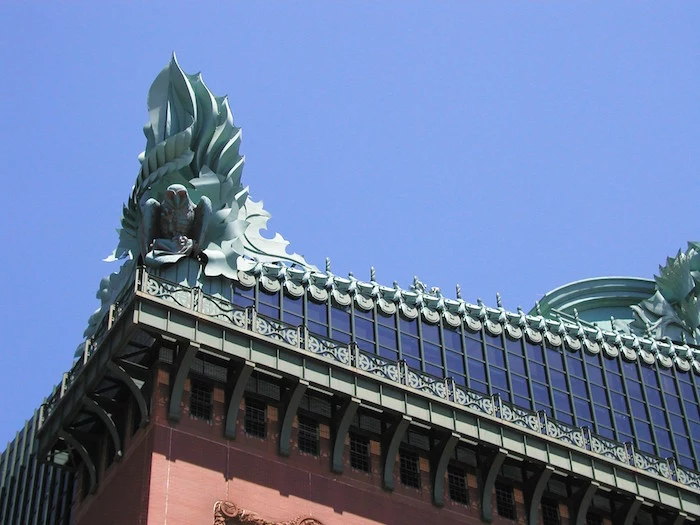 roof detail of the harold washington library, seen in close up, and featuring a bird and a flame-like ornament, postmodernism characteristics 