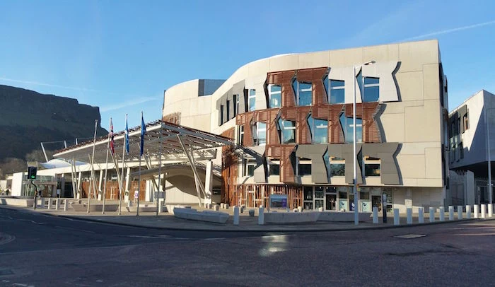 symmetrical building in cream, with brown and grey, and off-white details, postmodern design, scottish parliament building