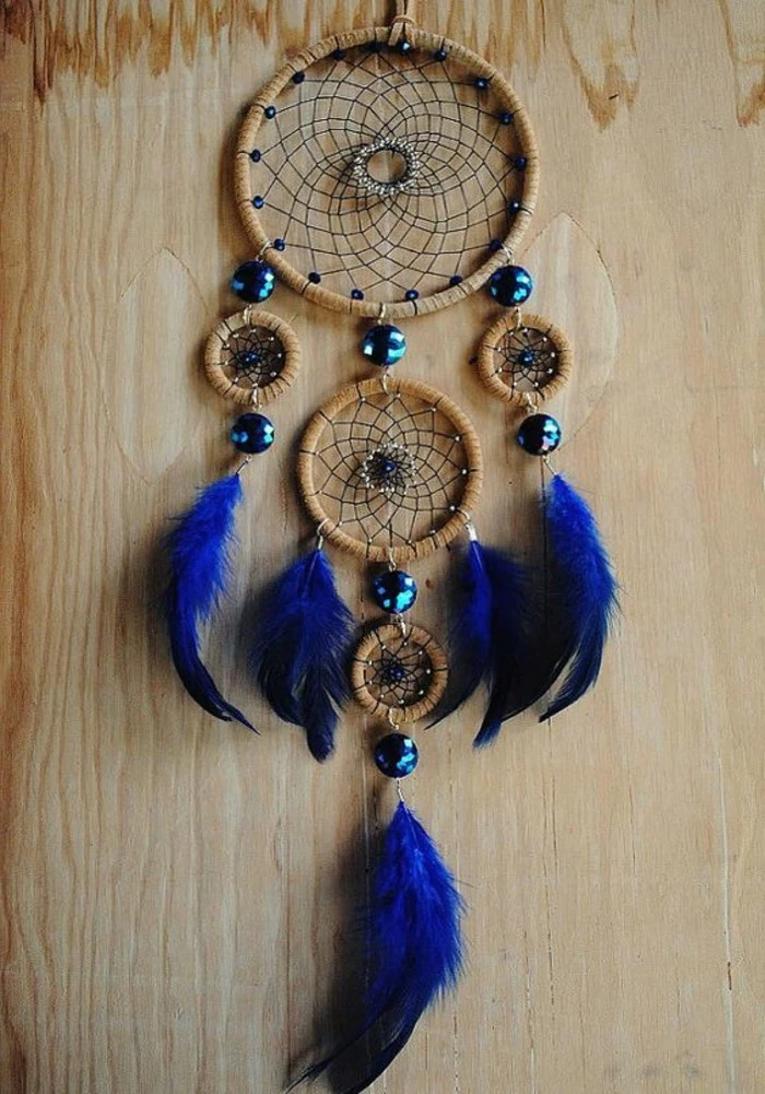 soft and fluffy, electric blue feathers, attached to a dreamcatcher, with five nets, and shiny turquoise beads