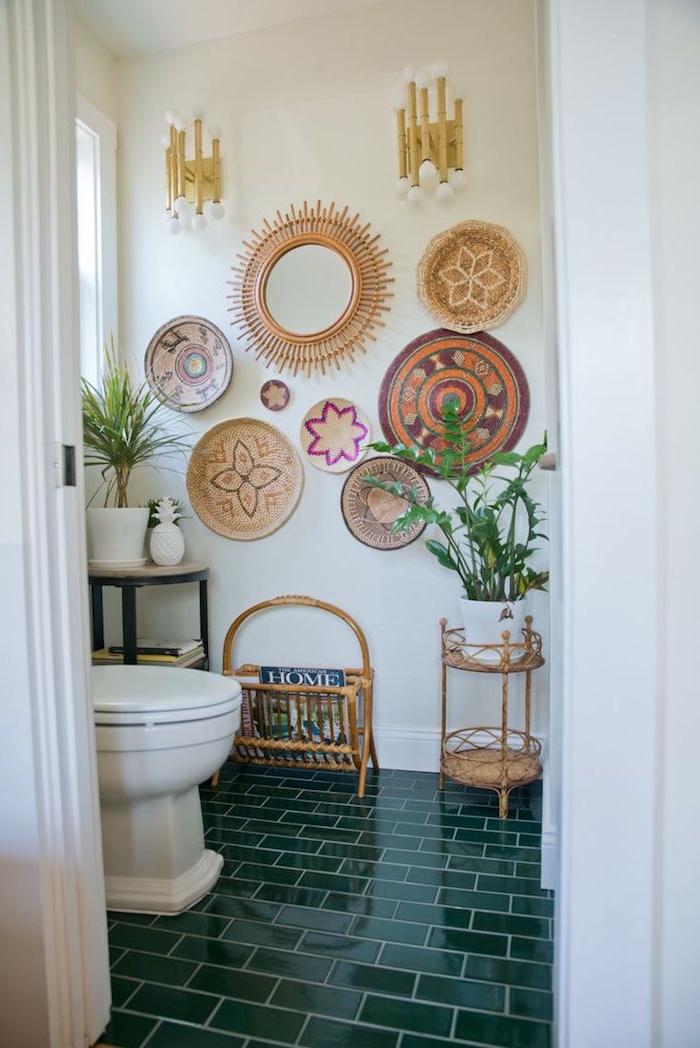 circular wall decorations, which ethnic patterns, on the wall of a room, with olive green, subway tiles on the floor, potted plants and a white ceramic toilet bowl, small bathroom décor 