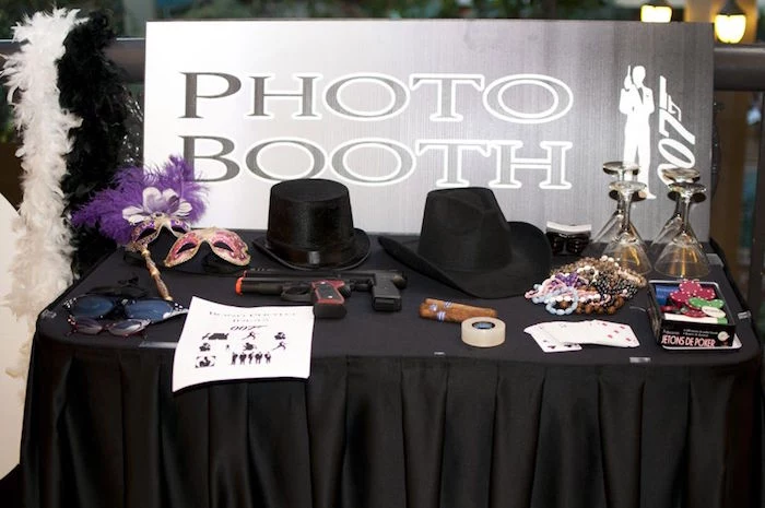 masks with feathers, sunglasses and hats, toy guns and cigars, cocktail glasses and other items, on a 1920s gangster-themed photo booth