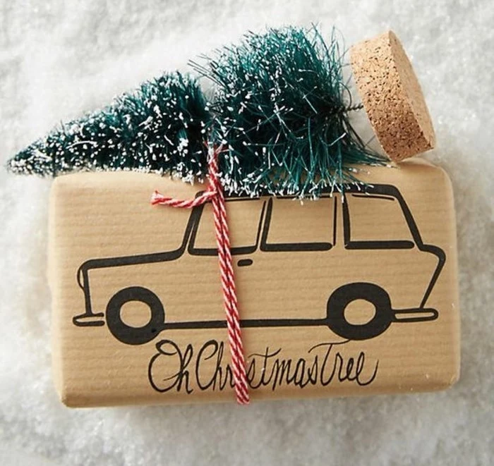 christmas tree ornament, tied with a white and red string, to a present, wrapped in beige paper, with a drawing of a car, handmade gifts