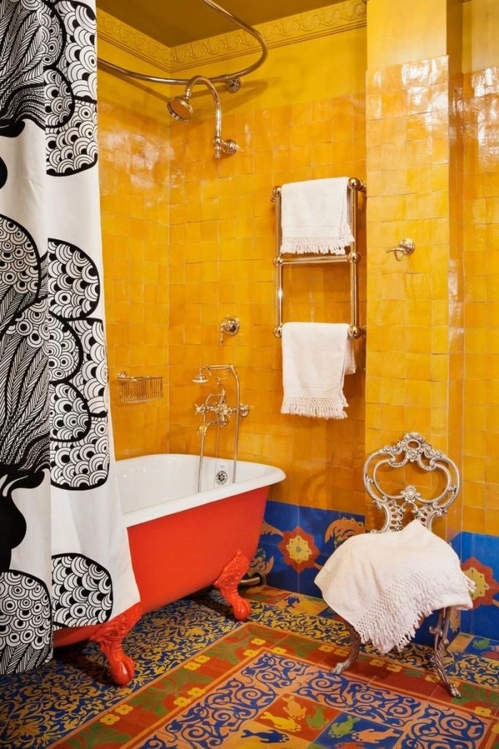 orange tiles with a glossy sheen, in a bathroom with a multicolored tiled floor, a red and white claw-footed tub, and a black and white shower curtain