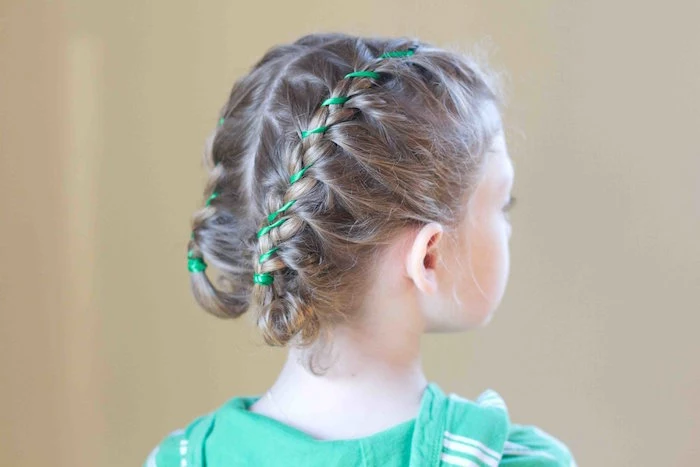 hoodie in green, with white stripes, worn by a child, with dark blonde braided hair, little girl hairstyles, decorated with green ribbons