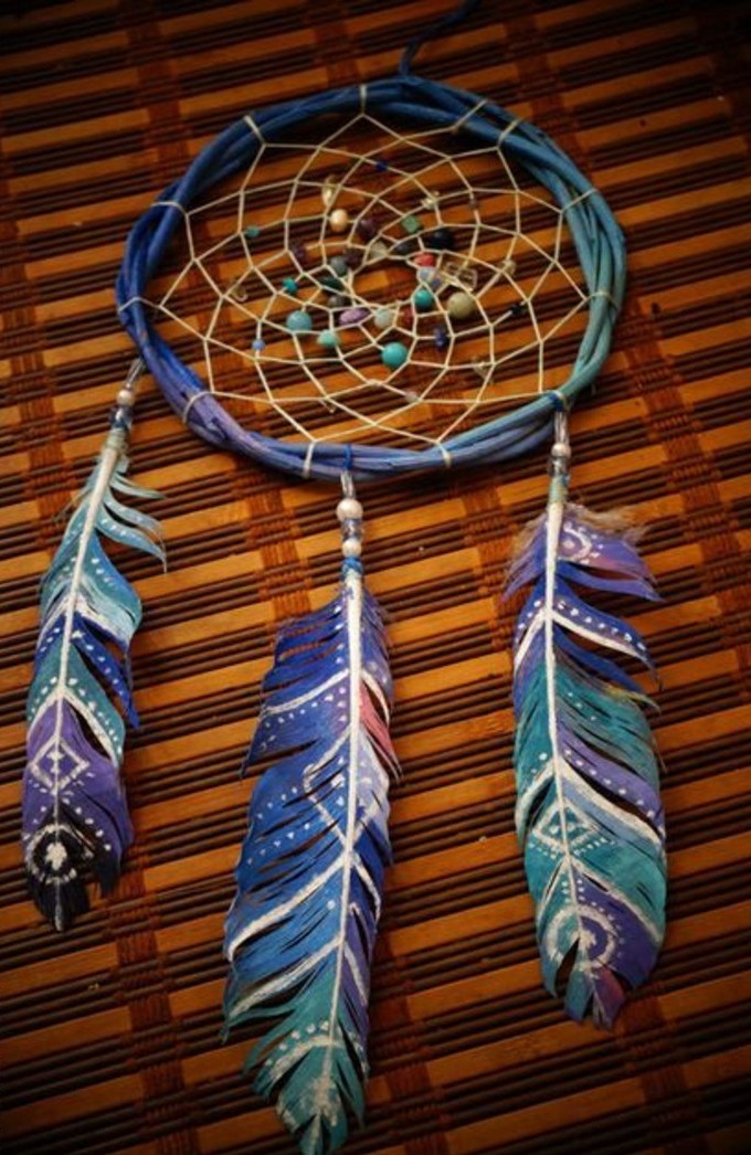 painted feathers in blue, purple and pink, with white hand-drawn symbols, attached to a handmade dreamcatcher