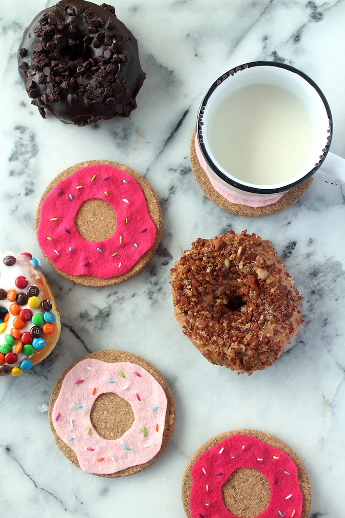 donut shaped coasters made with felt and cork, creative gift ideas, donuts scattered next to white mug, marble countertop