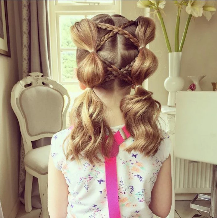 criss-crossing braids, on a child's honey blonde, shoulder-length hair, with pigtails tied in several spots, girl haircuts