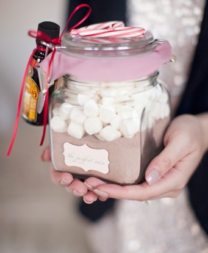 jar with a snap lid, containing cocoa powder, and white marshmallows, cute birthday ideas, small bottle of rum tied to it, two peppermint canes on top of the lid