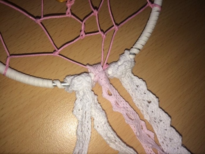 tying one pale pink, and two white, crochet lace ribbons, to the bottom of a white hoop, with pink net, how to make a dreamcatcher
