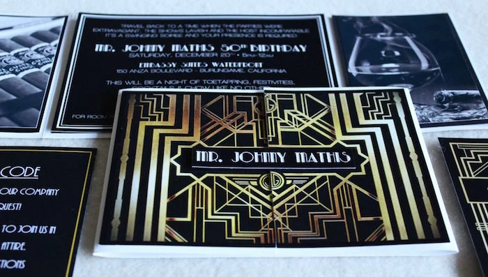 art deco invitation, in black and gold, for a roaring 20s themed party, placed on a white surface, near black and white images and leaflets