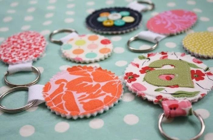 seven multicolored keyrings, made from patterned fabric, in round shapes, attached to metal rings, homemade gift ideas 