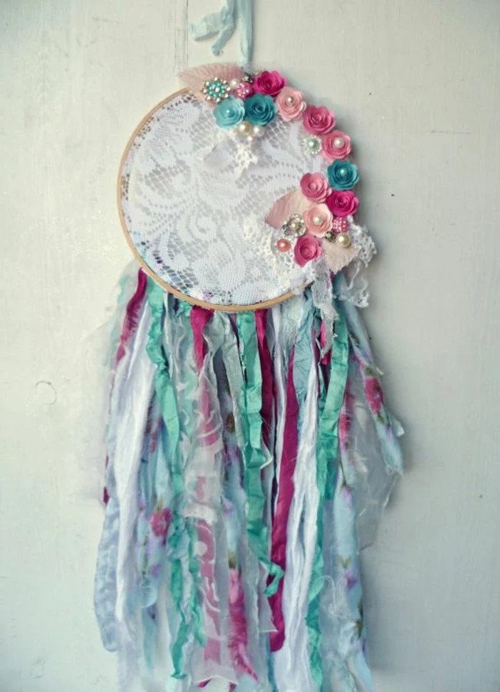 teal and pale pink, turquoise and dark pink floral motifs, on a dreamcatcher with white lace detail, dreamcatcher designs, many multicolored tassels 